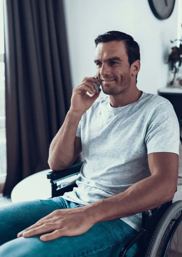 man in wheelchair on phone to niisq psychology occupational therapy queensland